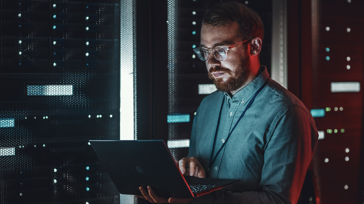 An IT professional checking network status on a laptop