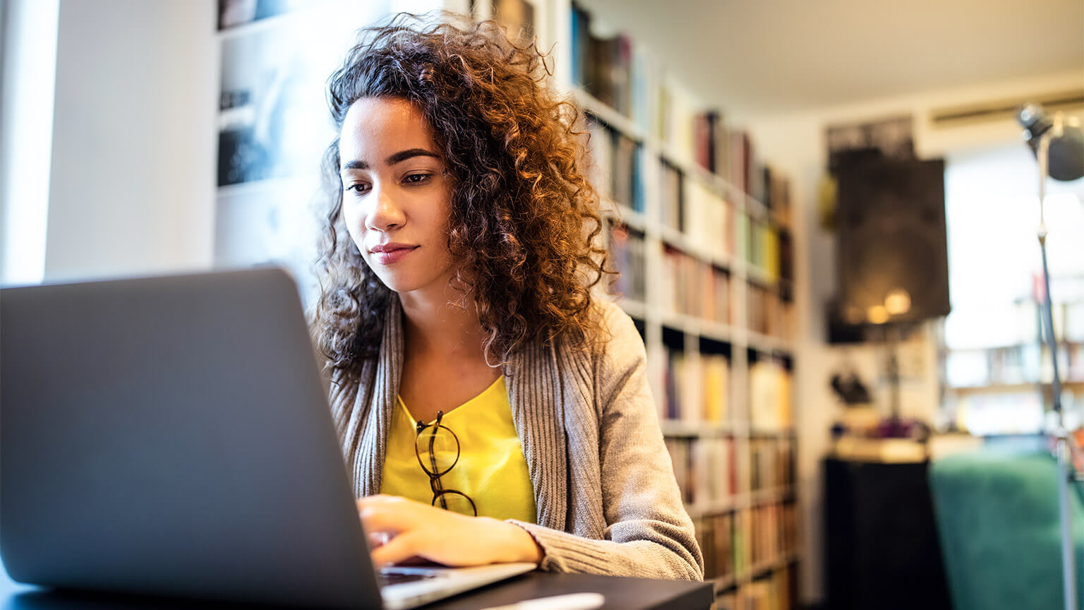 A student absorbing reference materials on their laptop