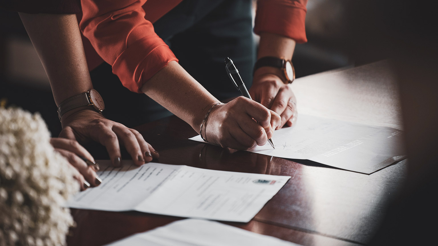 A close view of two parties signing a contract