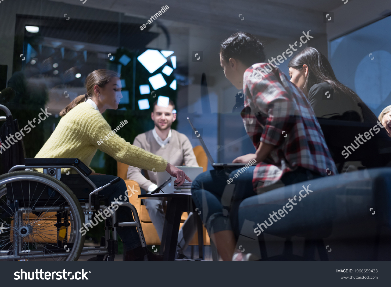 Office workers and person in a wheelchair discussing