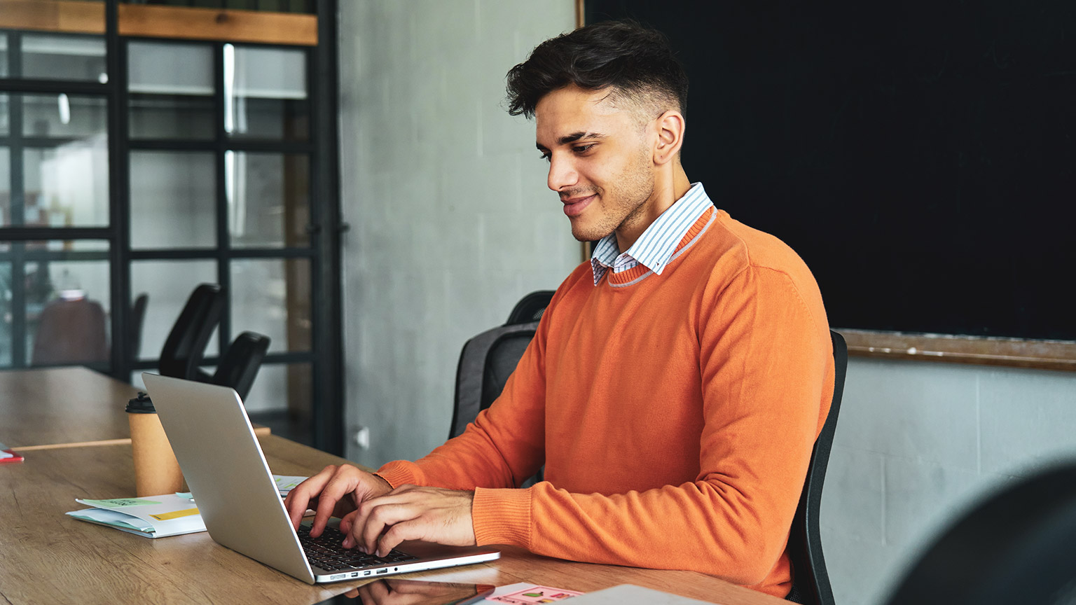 A young accountant working on a laptop in an office environment