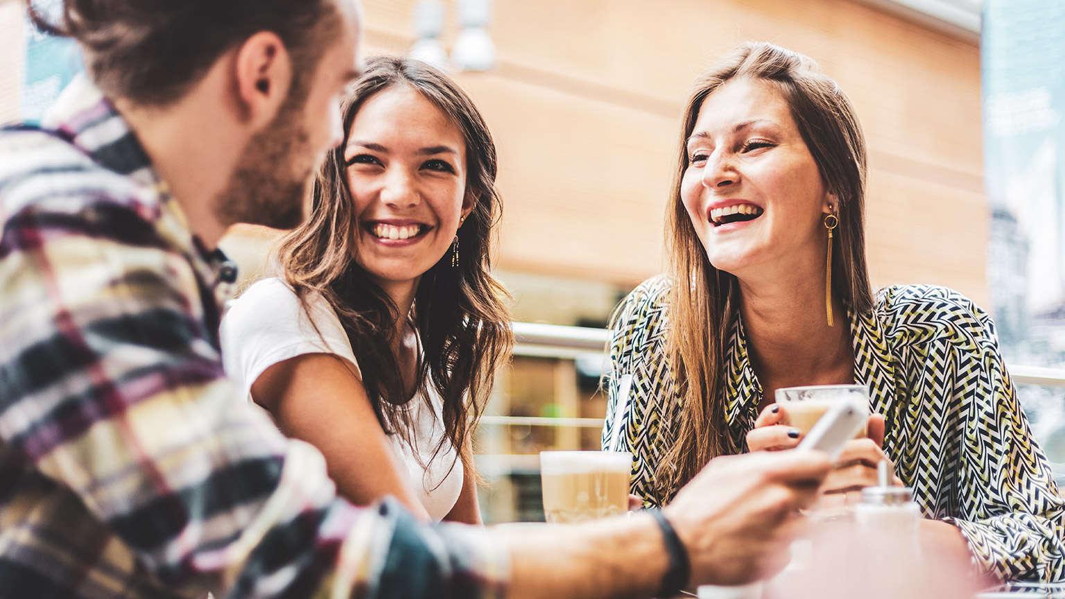 A group of friends seated at a table, holding a conversation in a relaxed environment