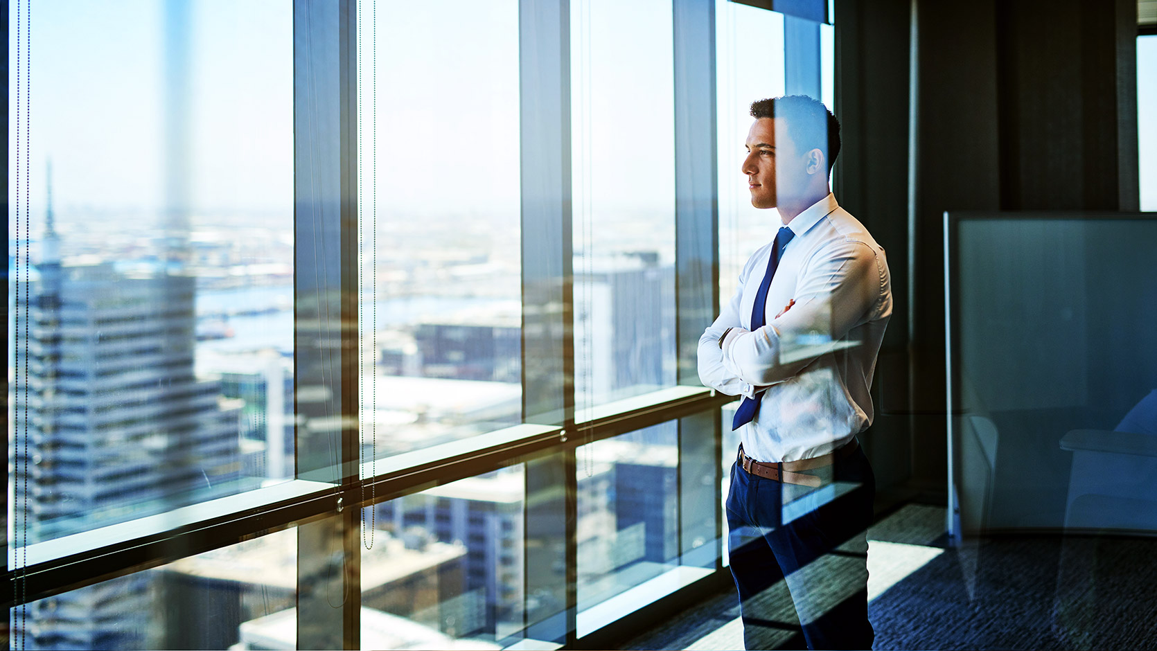 a young professional looking out their office window, mulling over a big decision