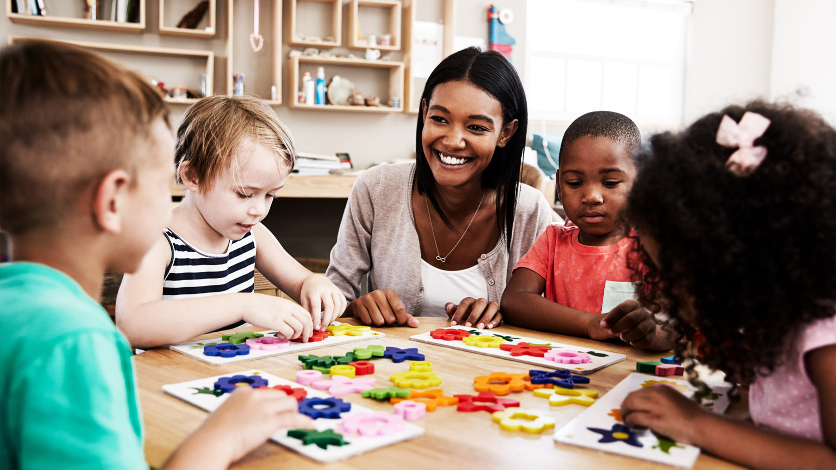 Teacher And Pupils Using Flower Shapes In Montessori School