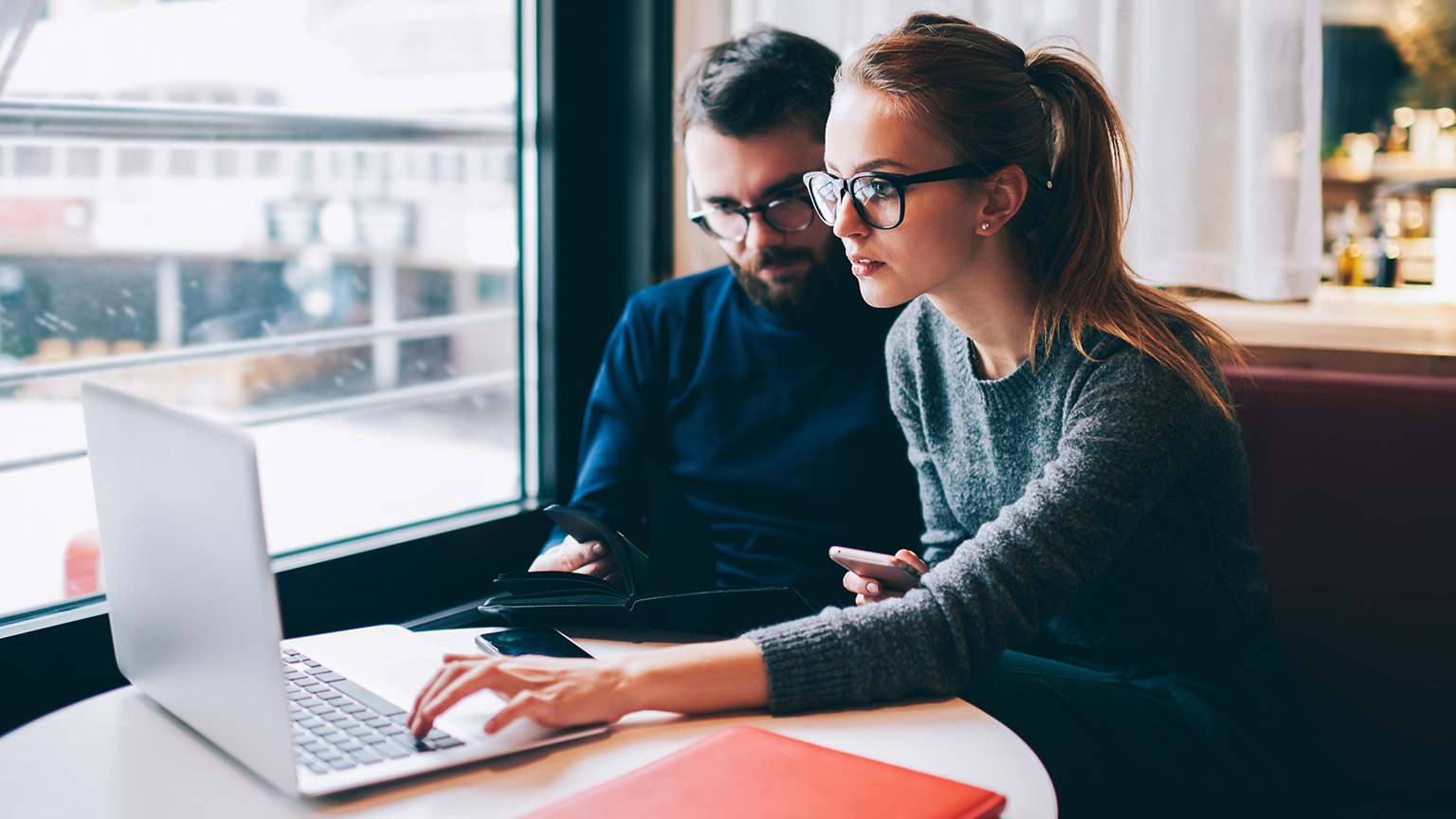 2 accountants checking if formulas are working correctly on a laptop computer