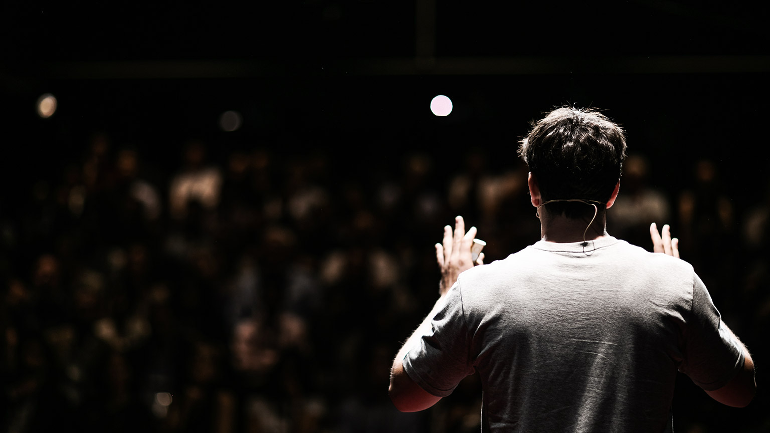 a speaker engaging their message to an audience in a large auditorium