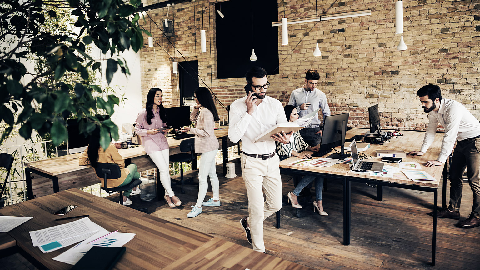 A group of young, successful business people working and communicating together in a modern office