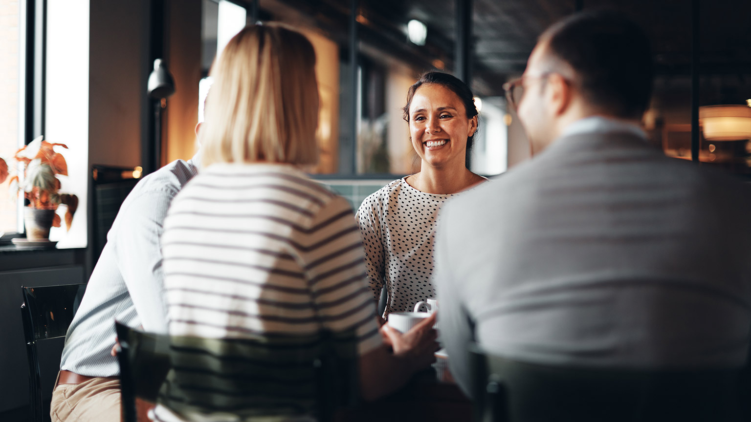 A group of business professionals discussing work in an office setting