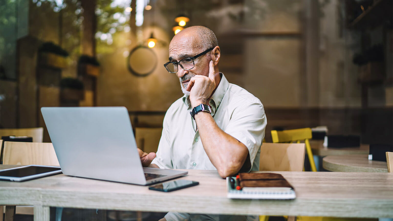 A professional seated in front of their laptop, absorbing reference material for a project they've been tasked with by their organisation