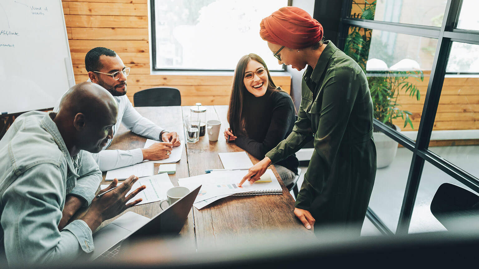 A diverse group of coworkers discussing a business project in a meeting room