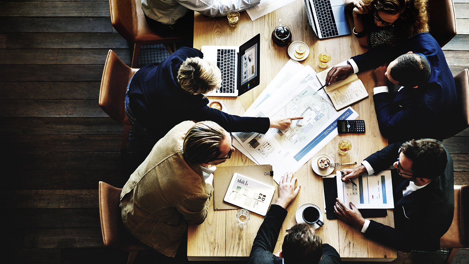 A small group of professionals interacting with each other in an open-plan office