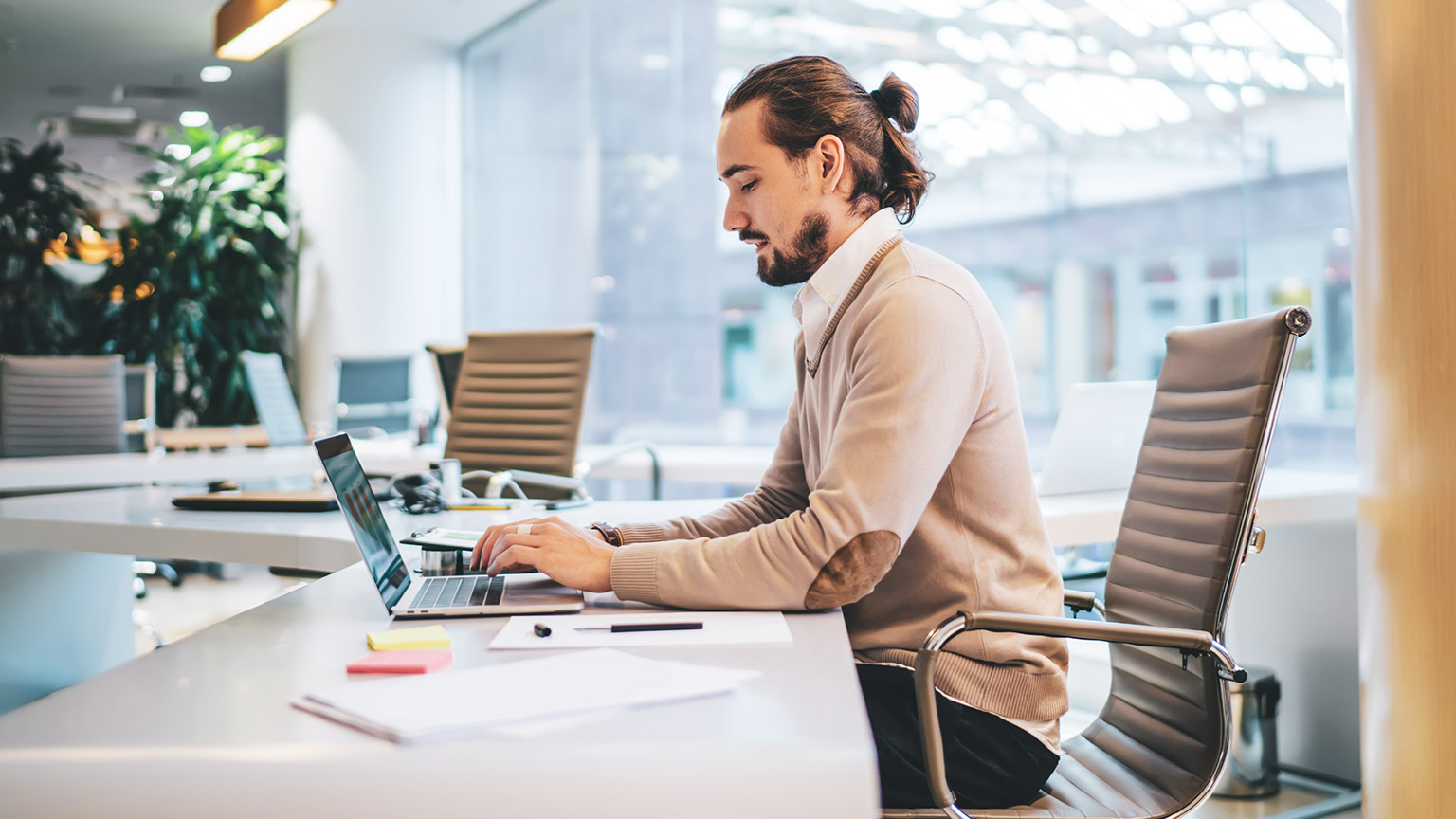 An accountant setting up a payroll system on a laptop in a modern office space