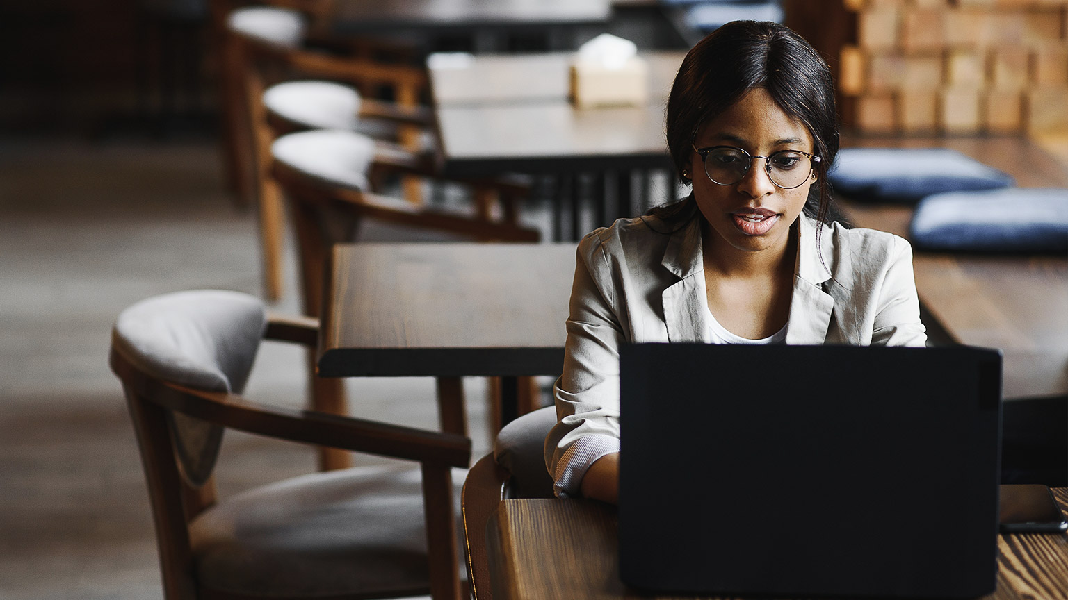 Young woman sitting at her desk with a laptop 