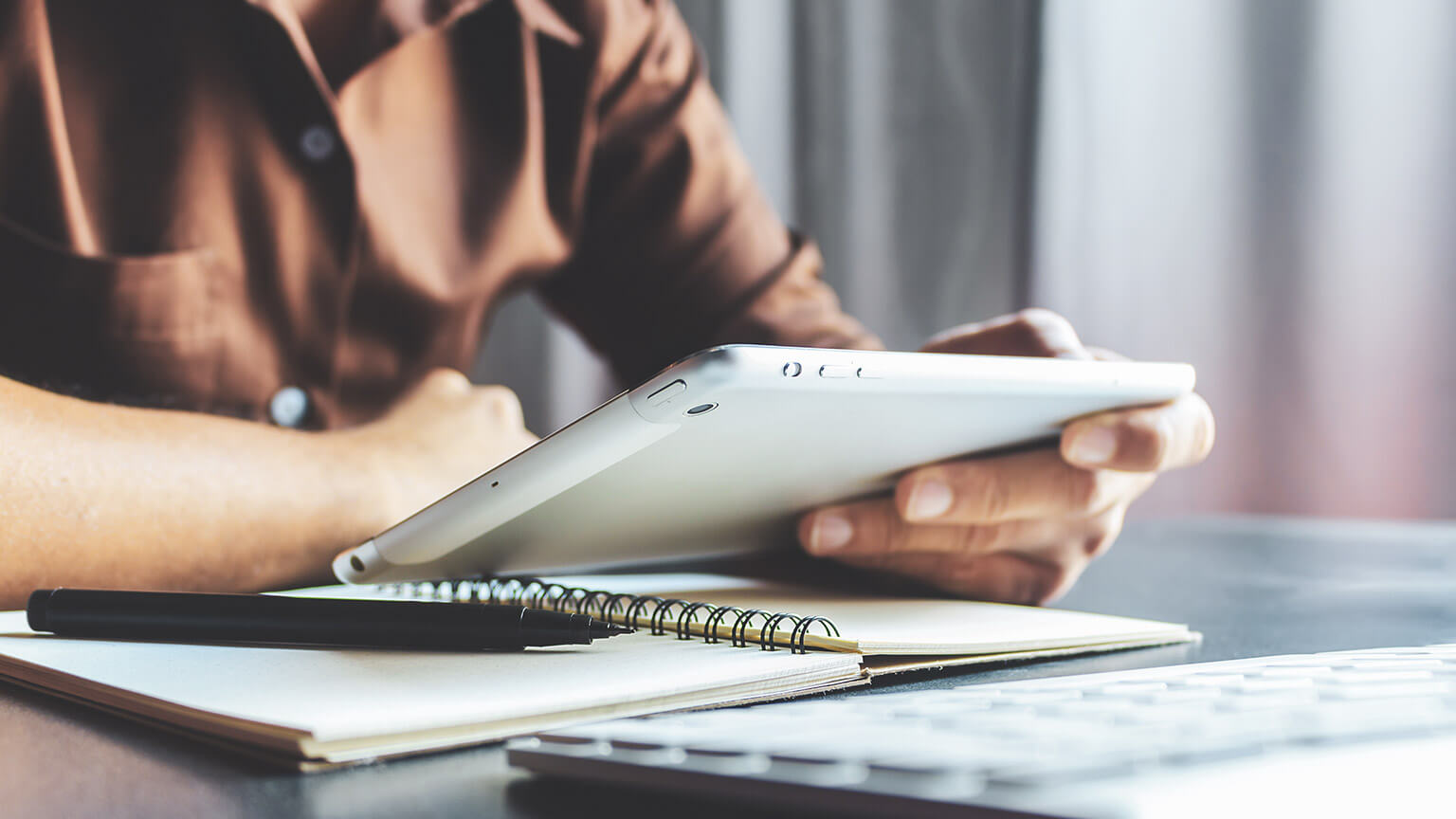 A close shot of an aged care worker reading relevant legislation on a tablet device