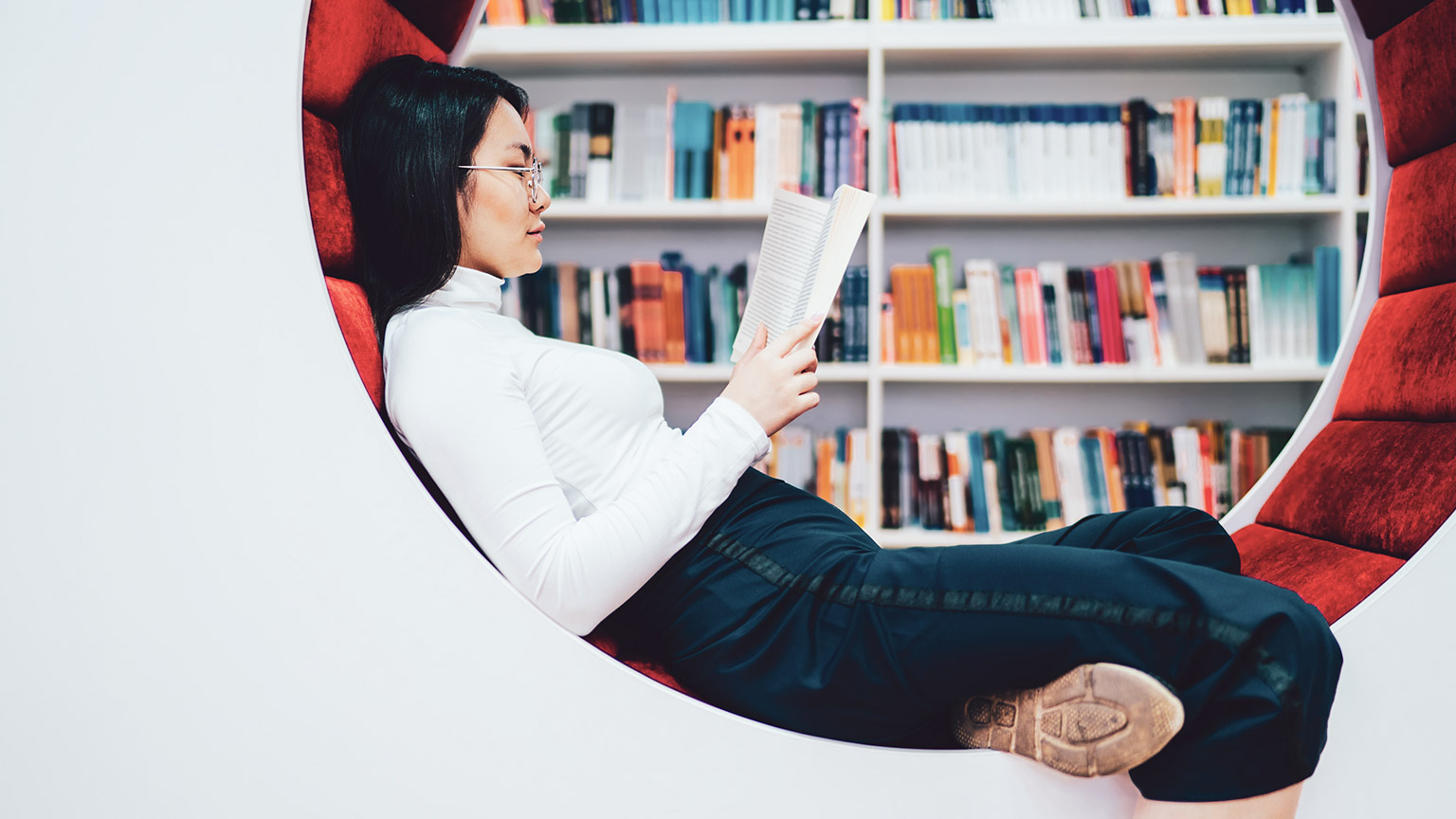 A student reading a book in a library