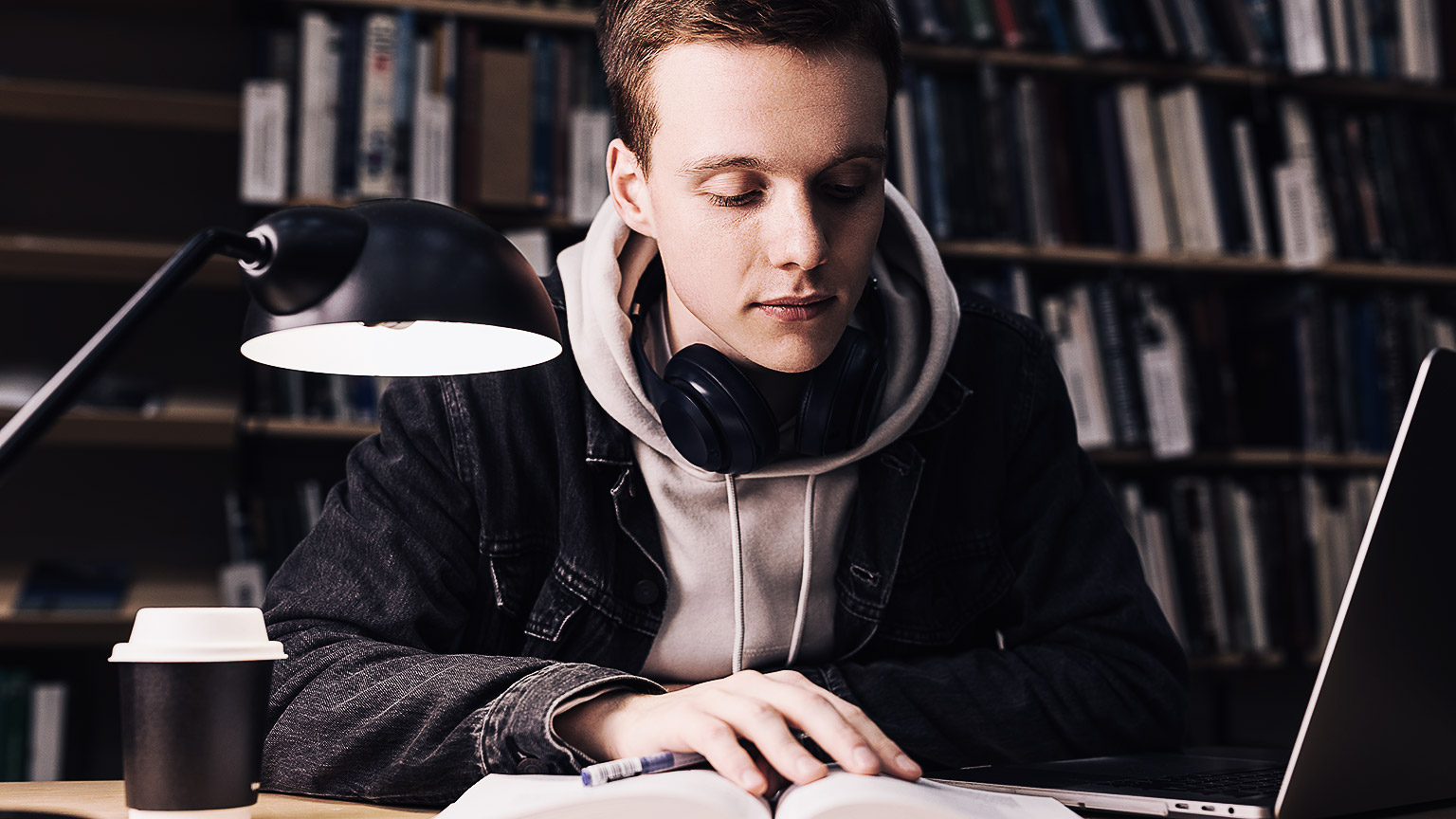 A person studying closely in a library