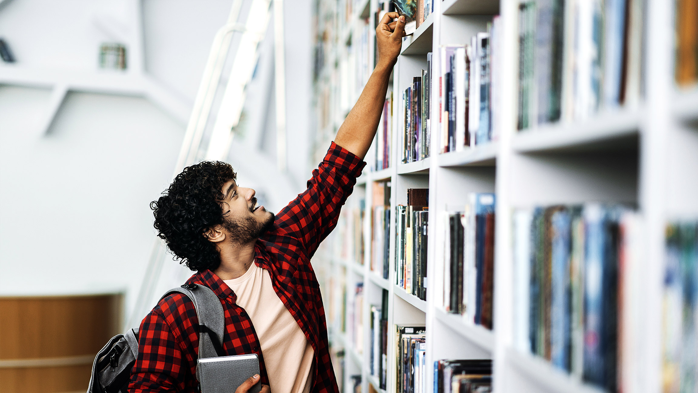 A person getting books from the library shelves