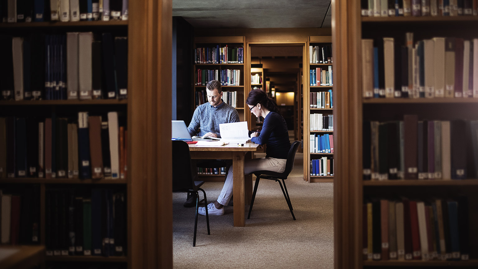 Two people reading in library