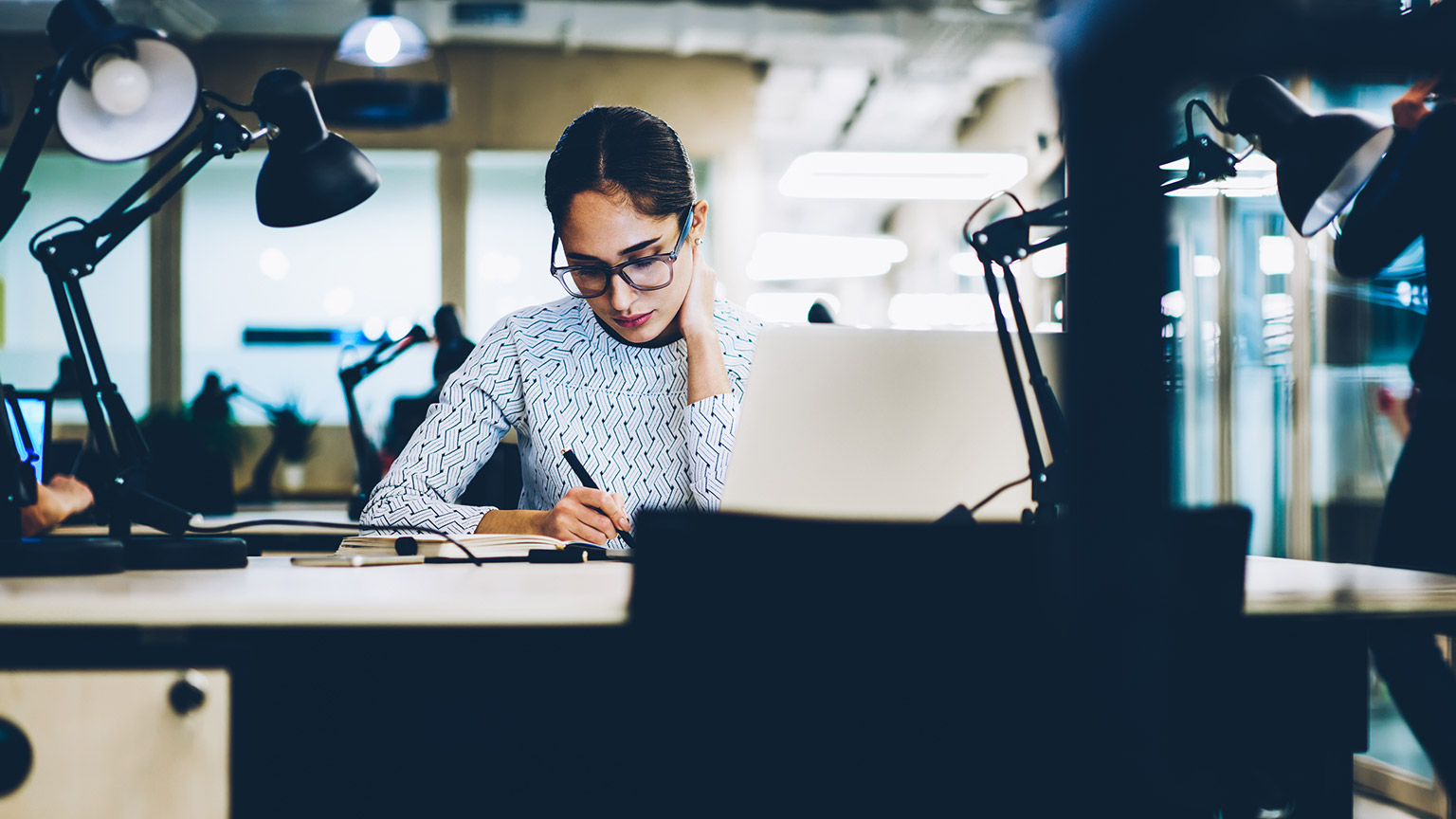 A manager sitting at a desk working on a meeting agenda