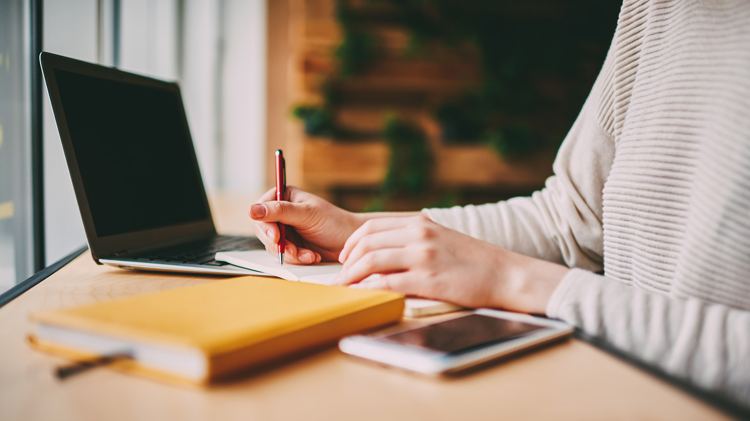 A close view of a person writing notes in a diary