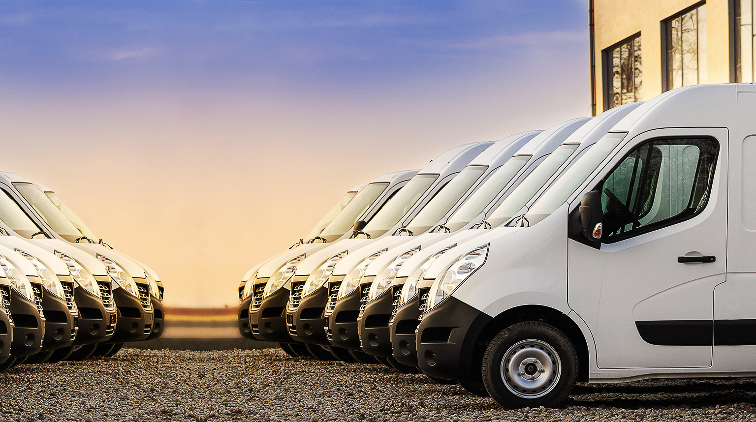 A row of vans with a sunset background