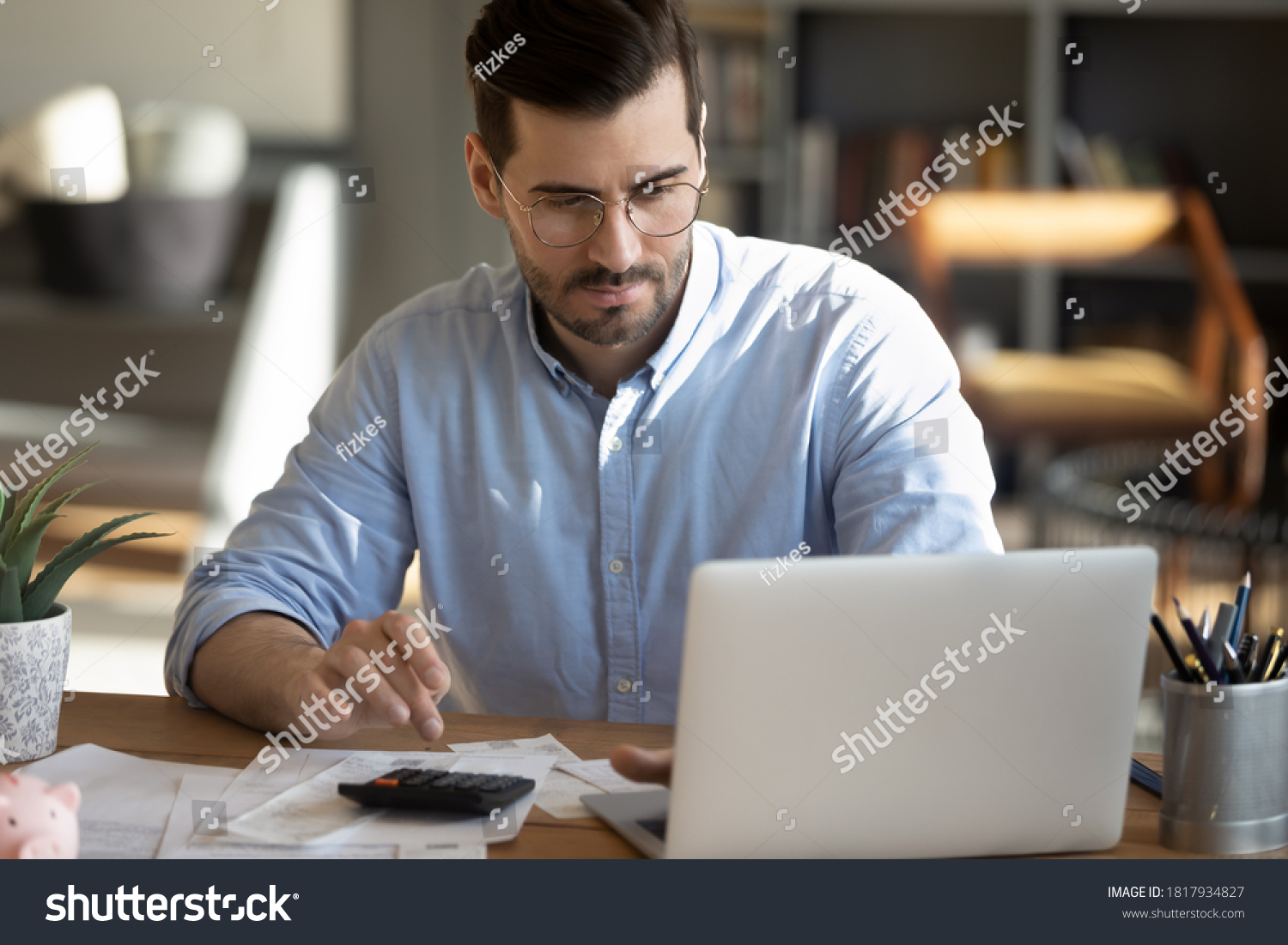 Male bookkeeper with laptop, papers and calculator 