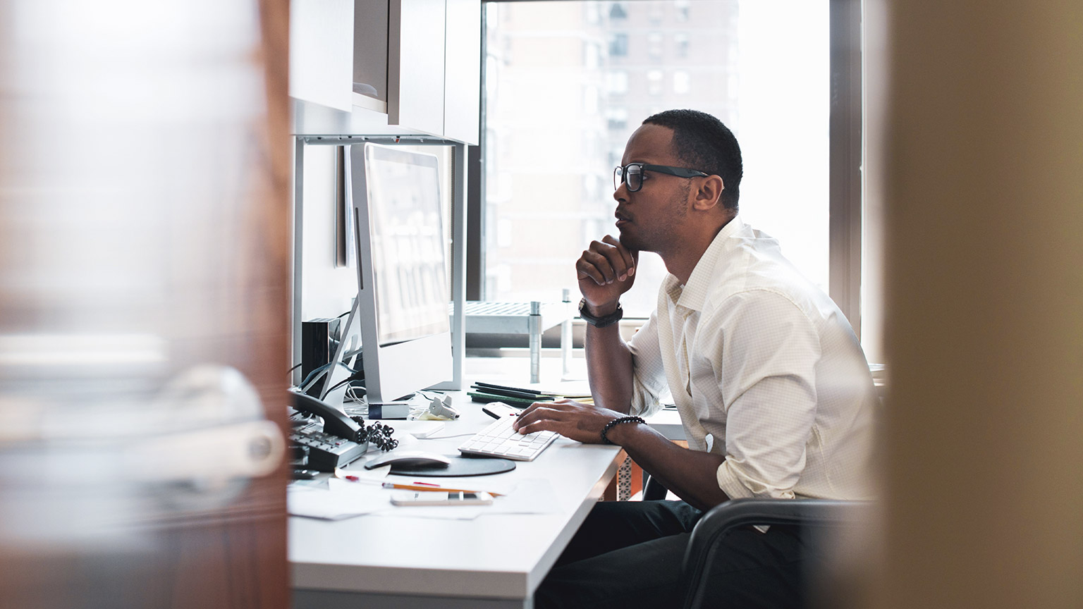 An IT professional working on network issues on a desktop computer