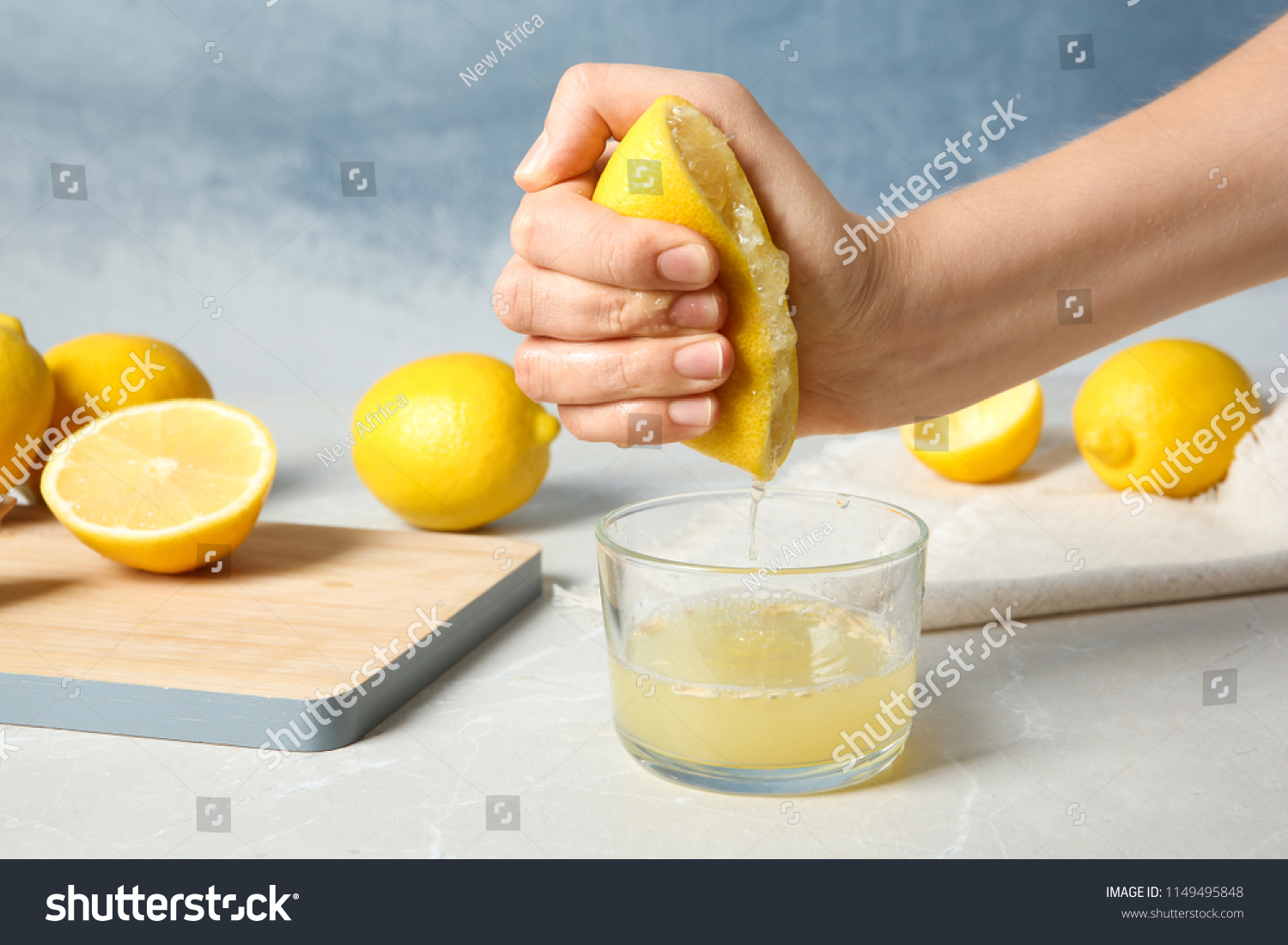 Hand squeezing lemons to make lemonade