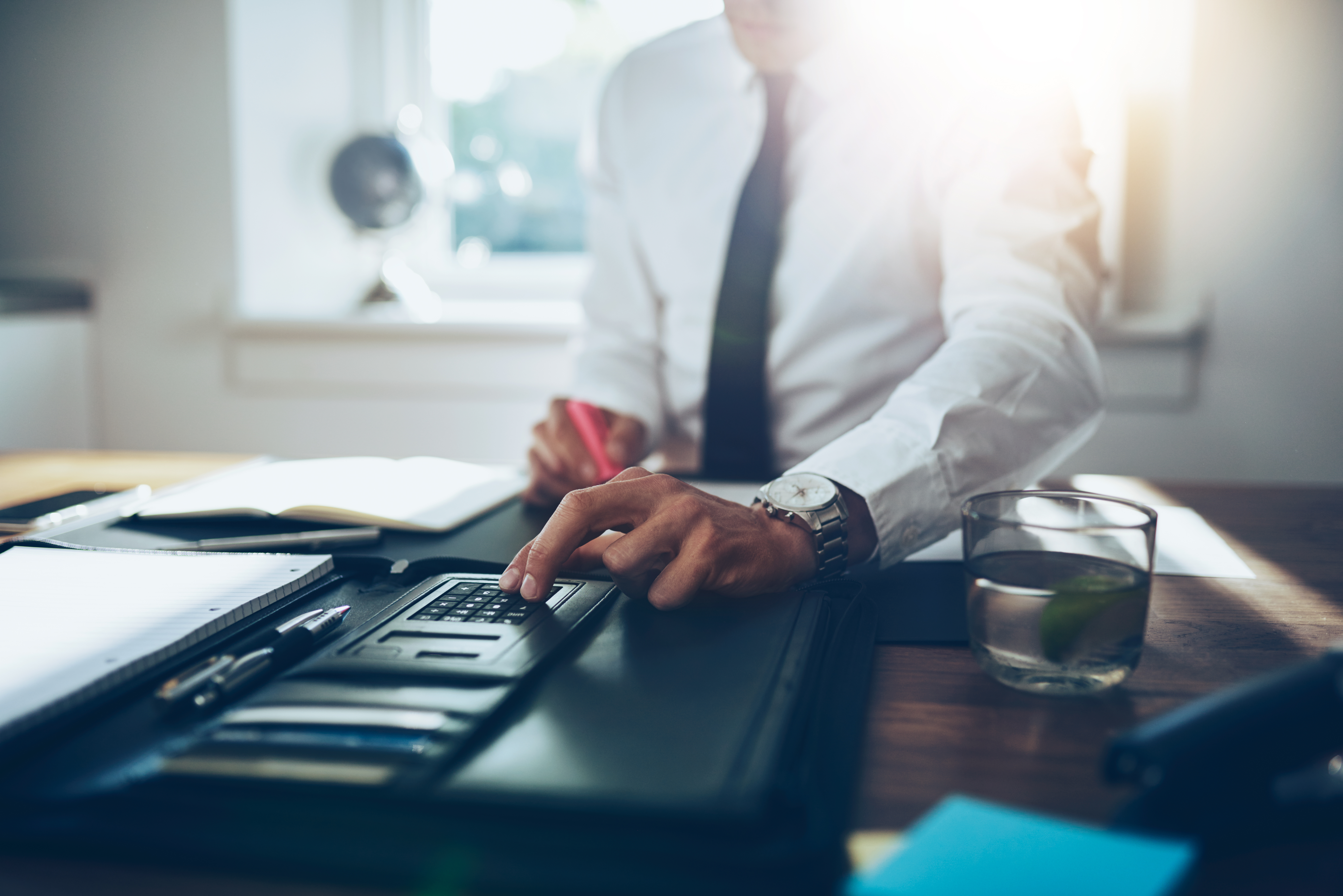 close up, business man or lawyer accountant working on accounts using a calculator and writing on documents