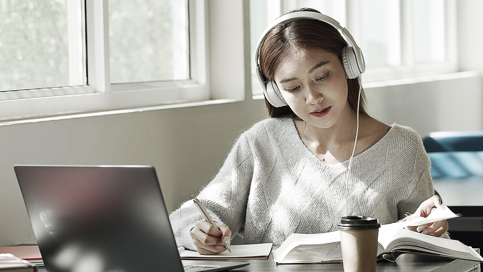 A person researching and reading books in a library