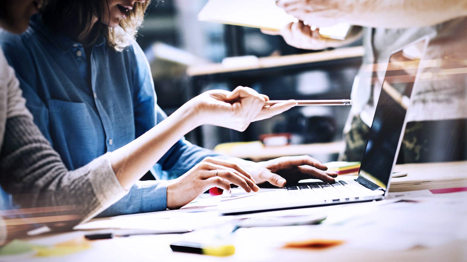 hands of coworkers pointing at computer screen