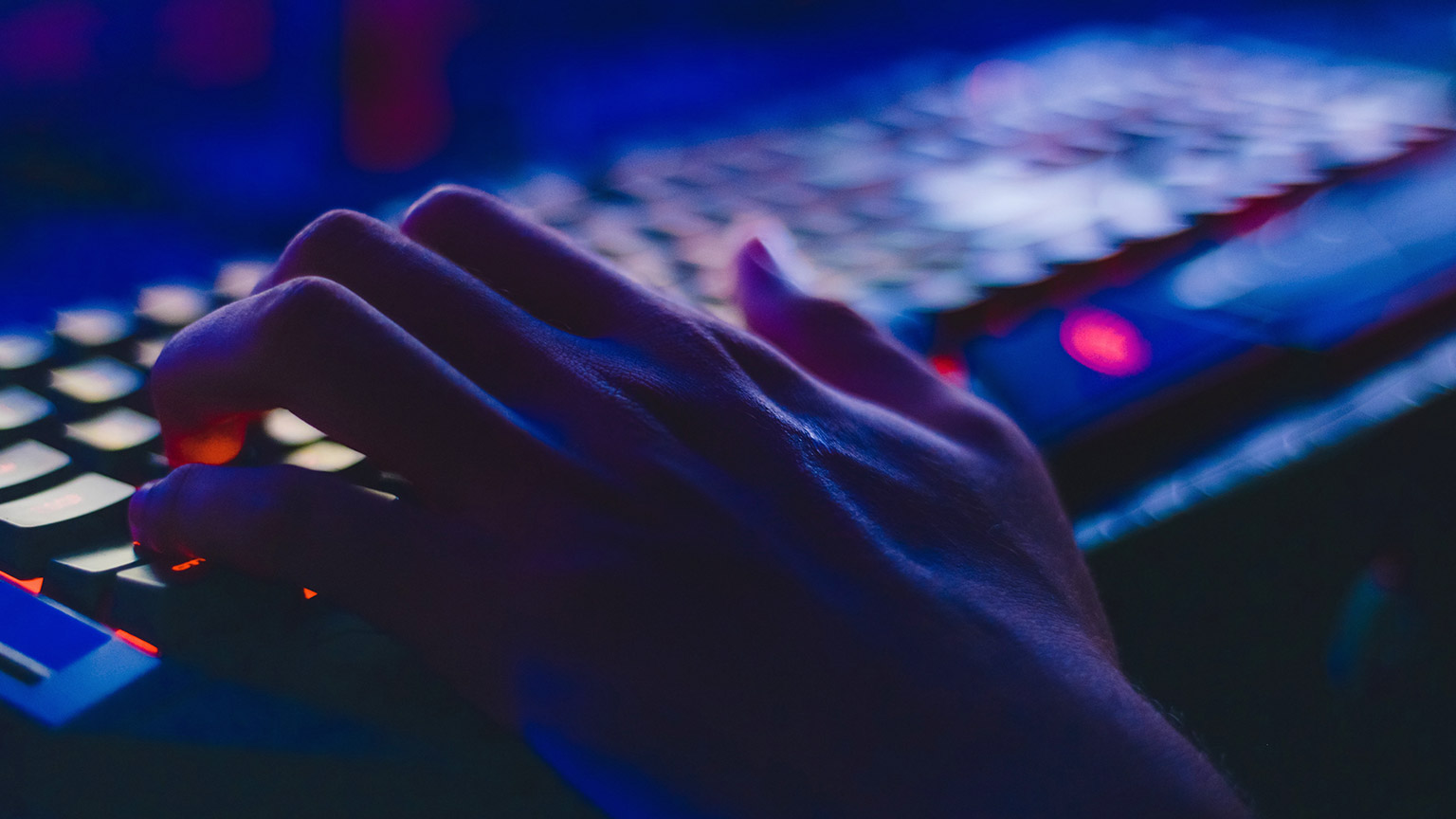 A close view of a gamer's hands on a keyboard