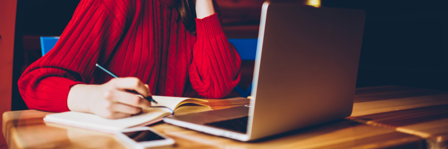 Person in a red jumper on a laptop