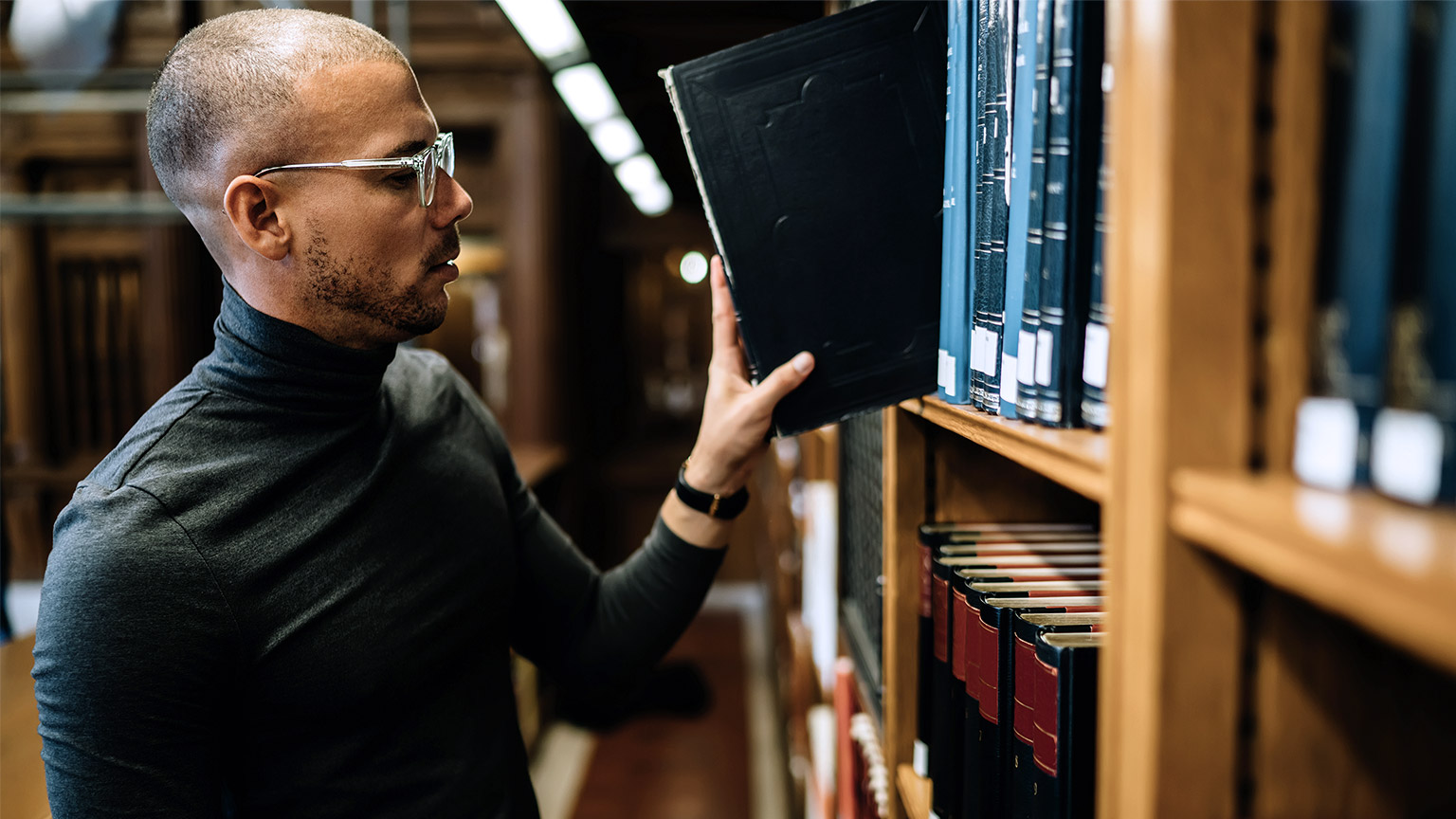 man taking out book from library