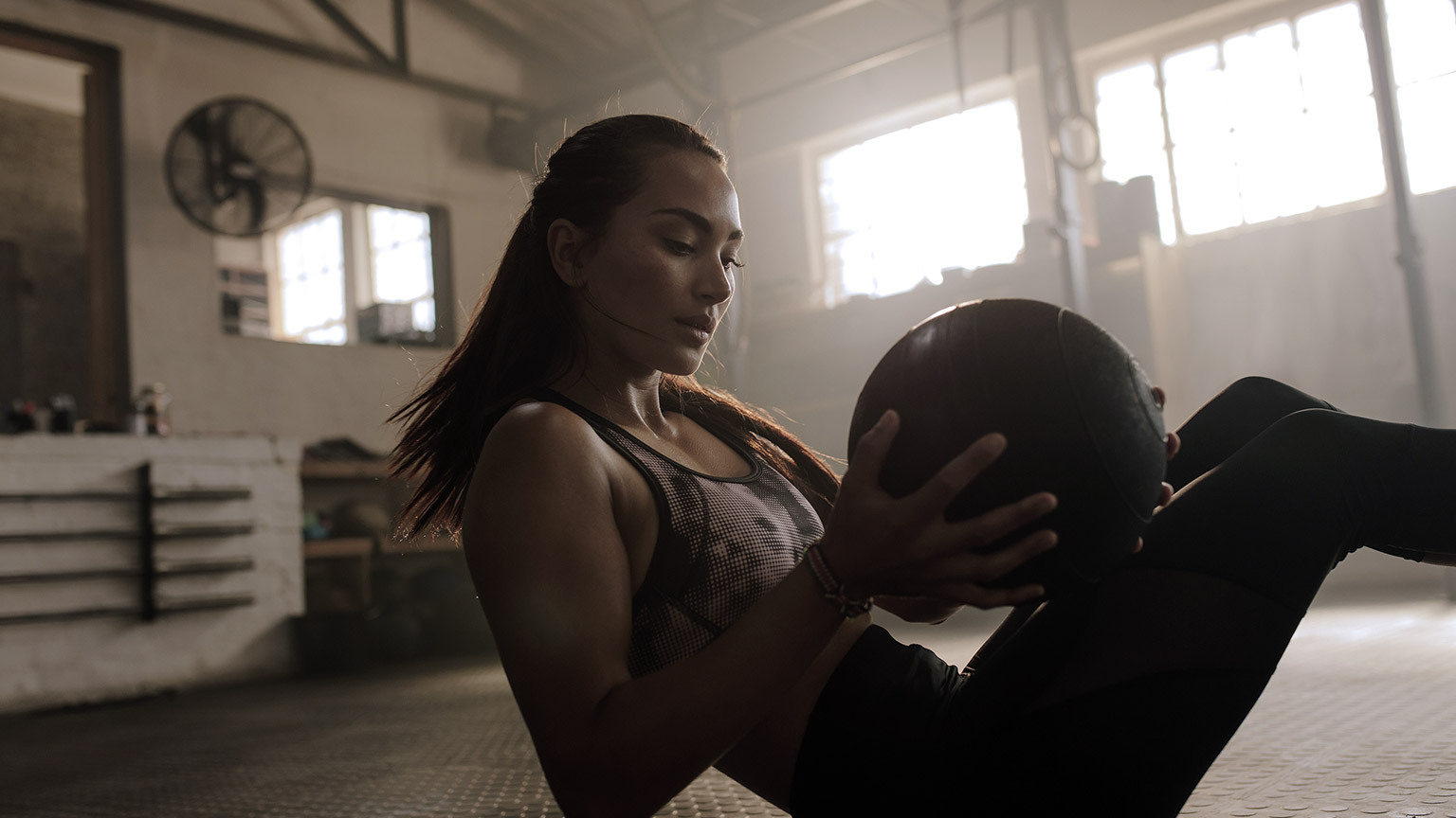 Young woman working out with fitness ball