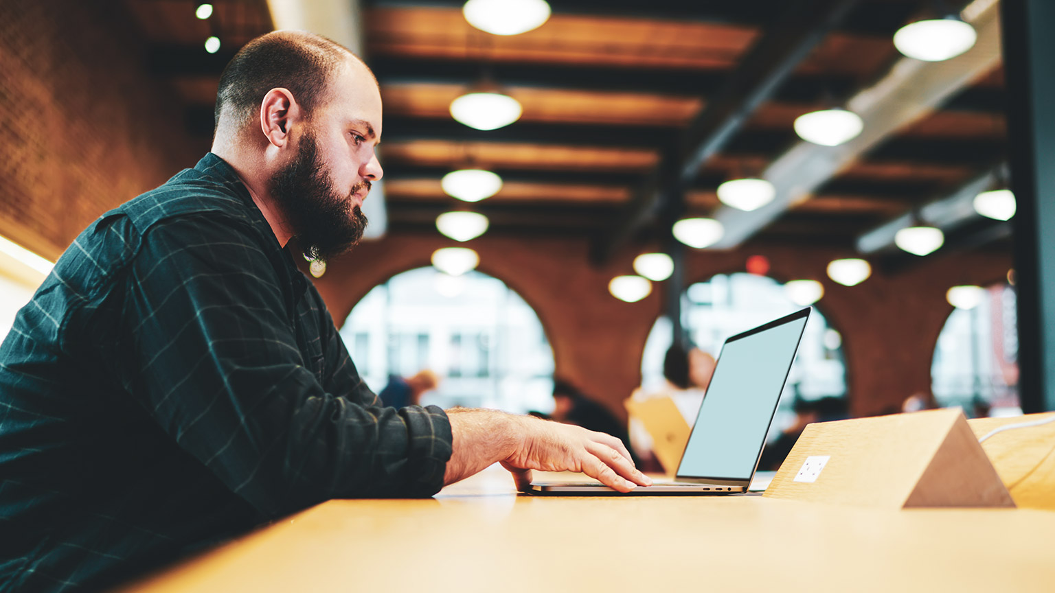 A programmer working on a laptop in a modern office space