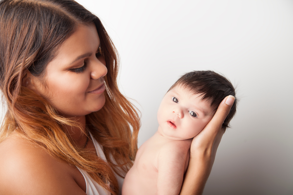 Young Australian Aboriginal mother holding her newborn baby.