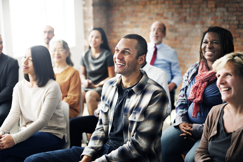 Community Seminar. Group of happy people sitting together listening and talking 