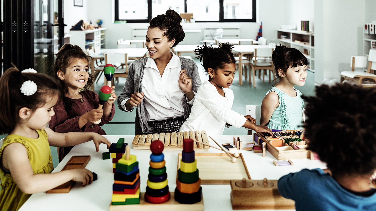  Several diverse, young children in daycare with their teacher