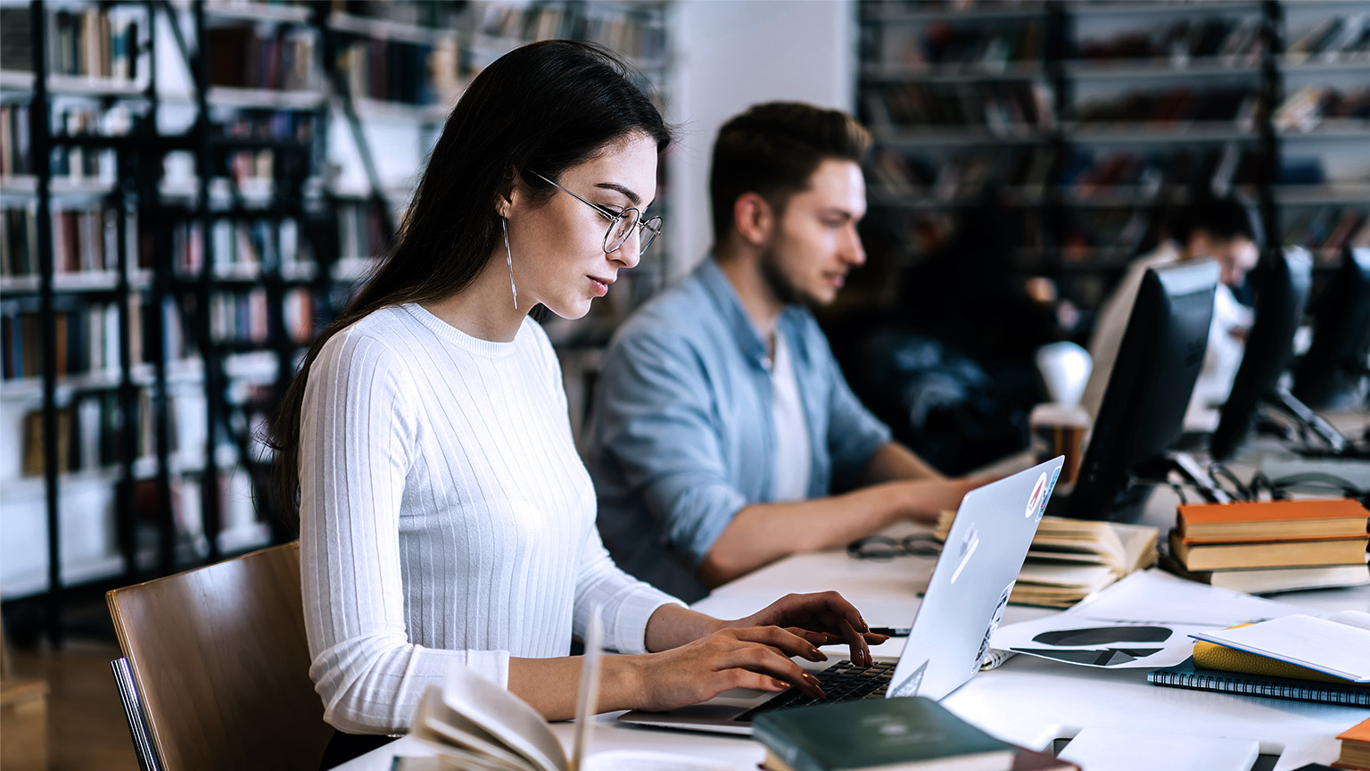 People at the library with books and computer