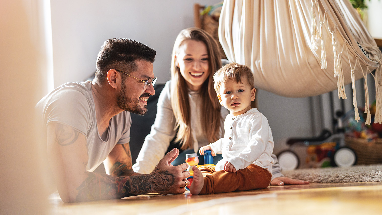 A young family playing with their child in a modern home