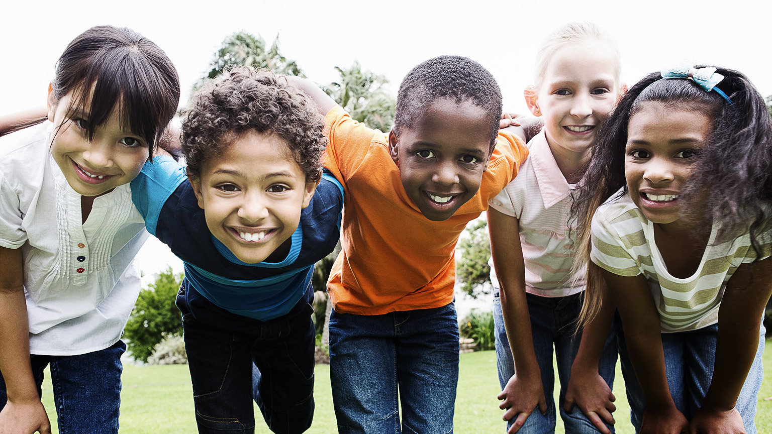 A group of children happily with a welcoming smile