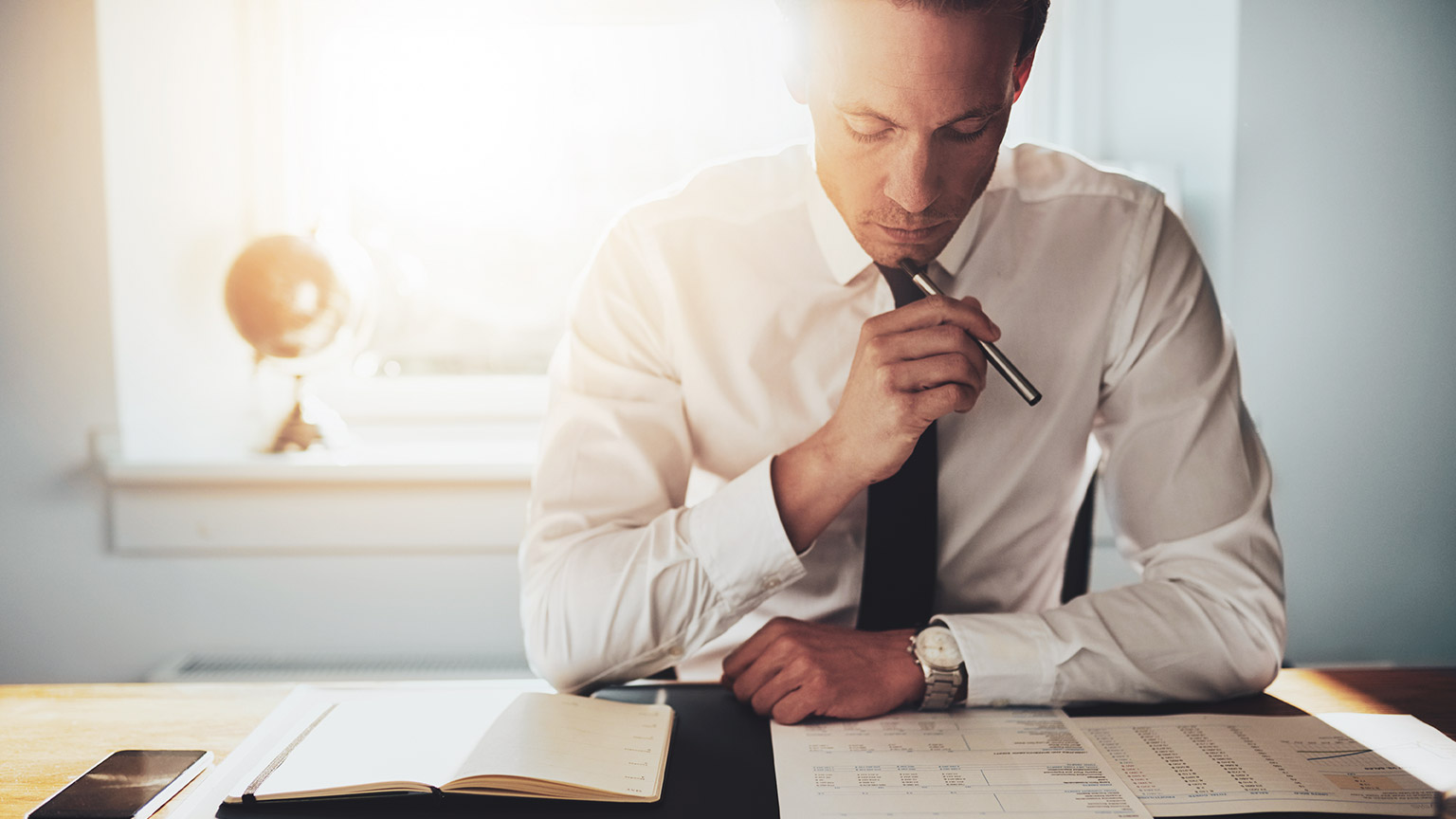 An accountant reading over document and appears deep in thought