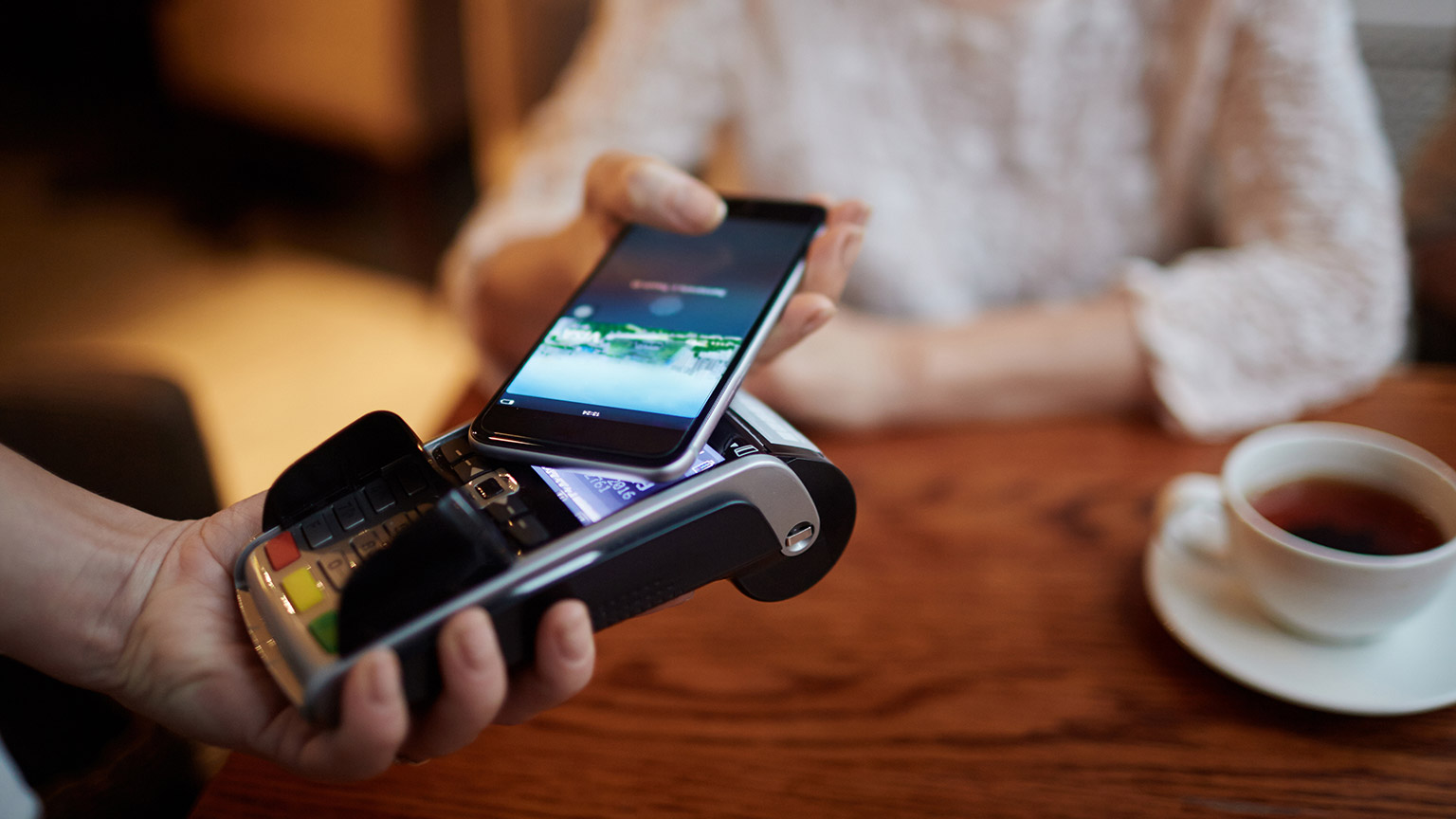 A close view of a customer using their phone to pay for food