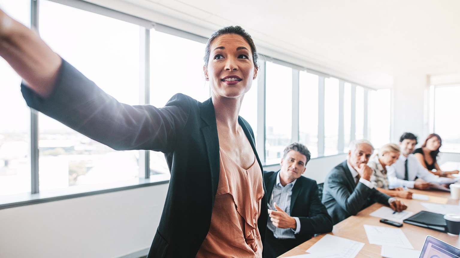 A manager presenting data to colleagues in a boardroom