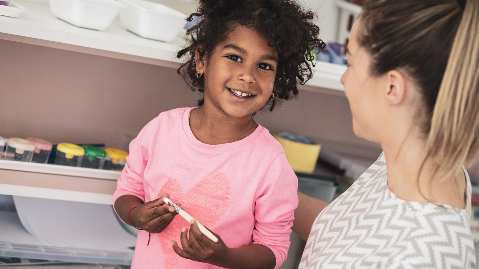 A child with a teacher in a school room