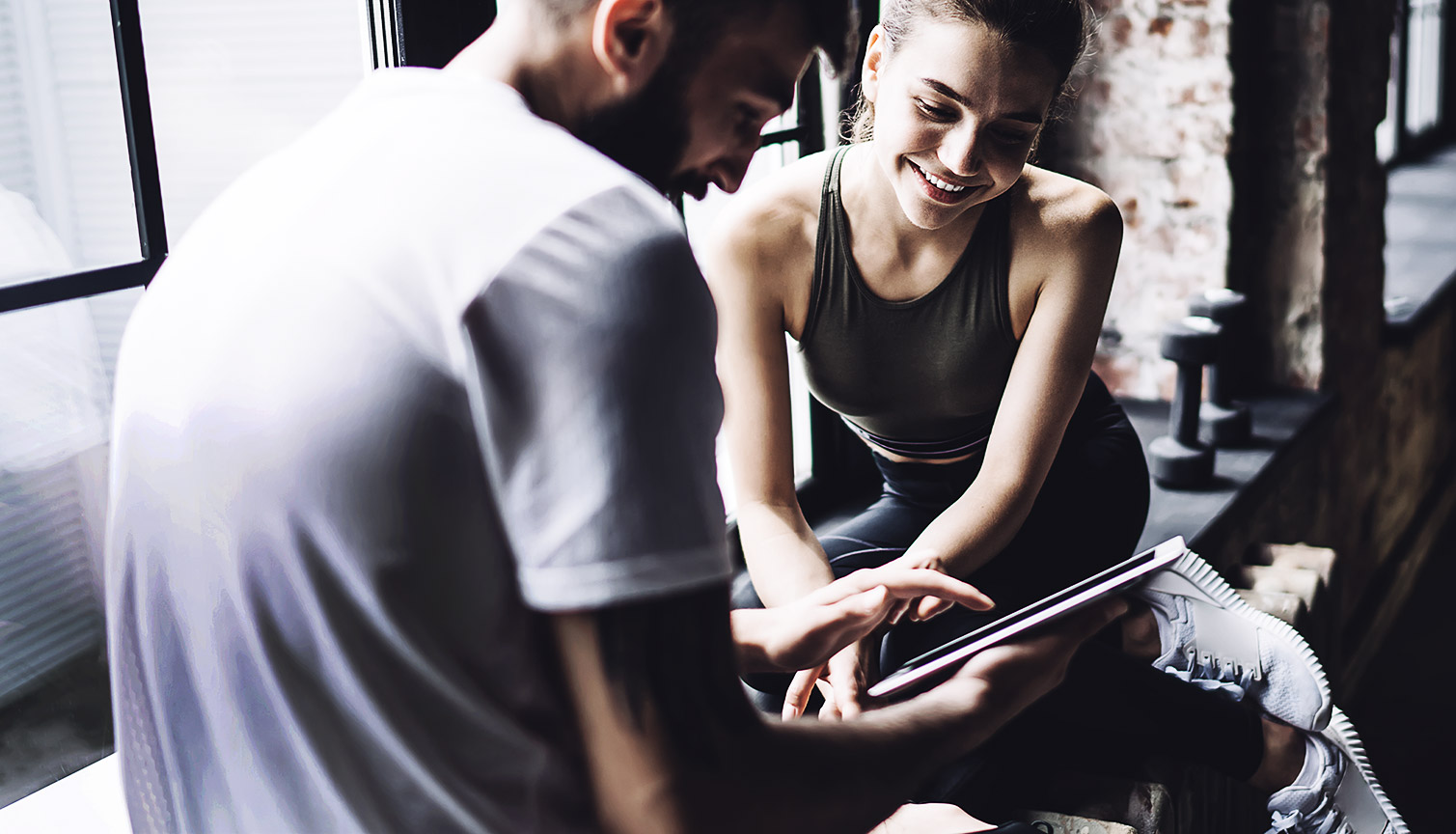 A couple of gym goers looking at websites