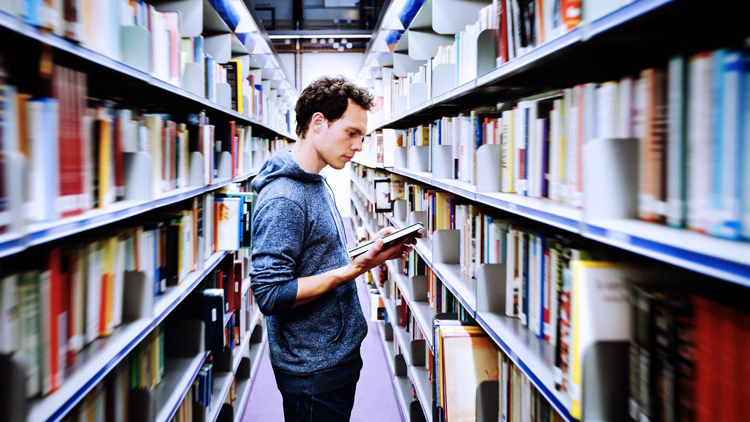 Student reading books inside the library