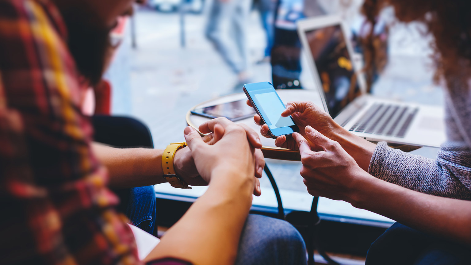 A group of friends using multiple devices to communicate