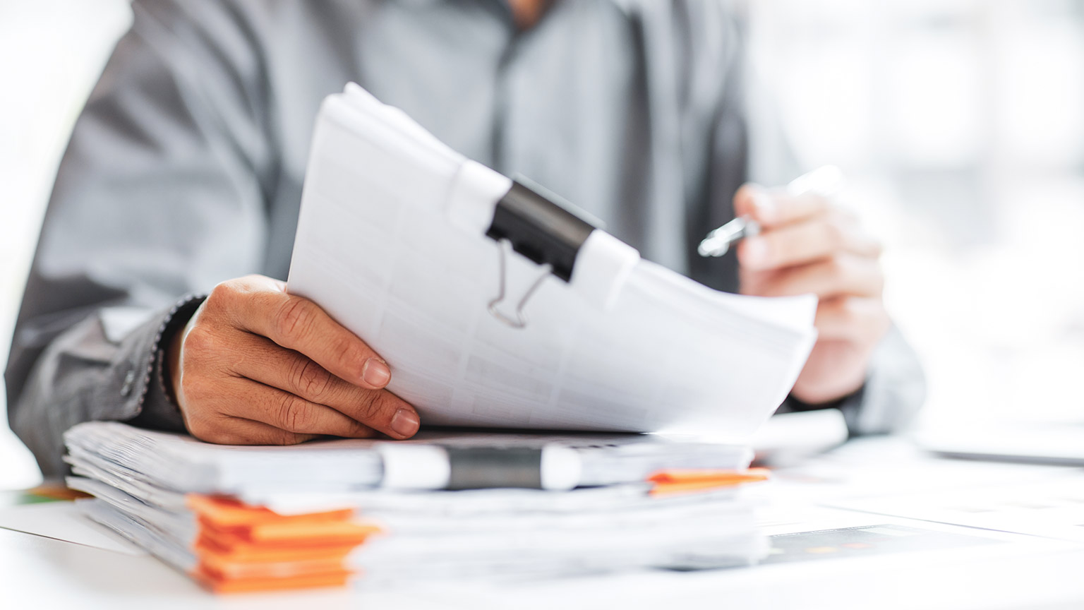 A close view of a person reading legislation paperwork